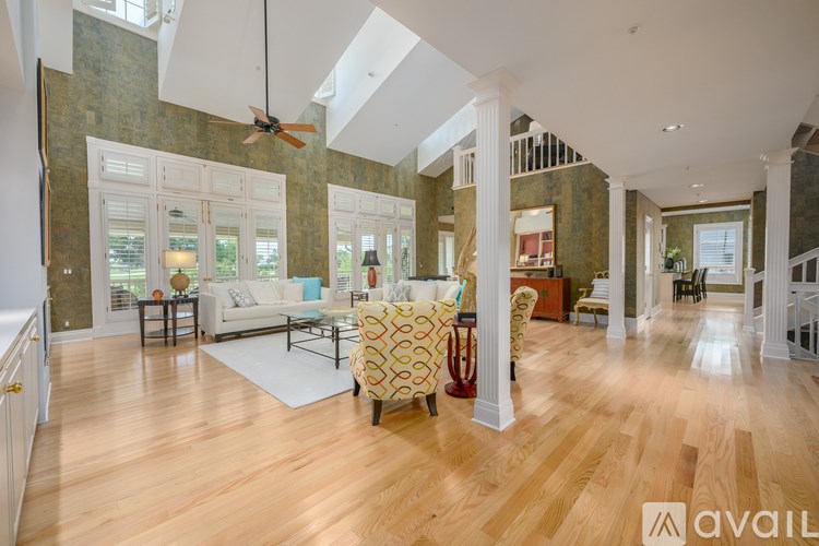 A spacious living room with wooden floors and a large window.