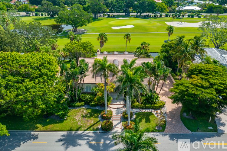 A golf course surrounded by trees and a house.