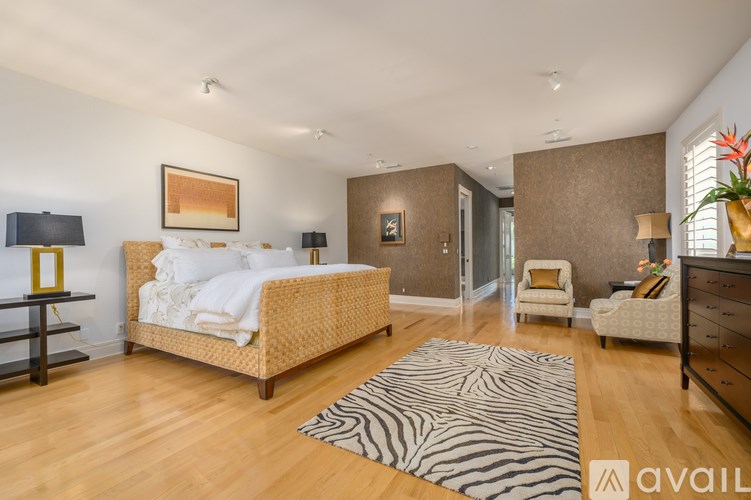 A bedroom with a bed, dresser, and chair.