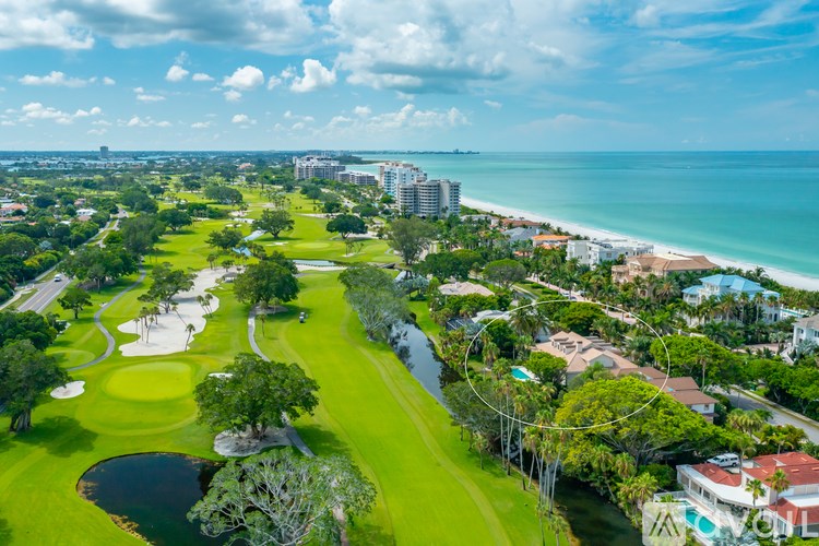 A golf course with a green and a lake.