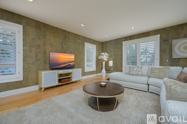 A living room with a television, a white couch, and a coffee table.
