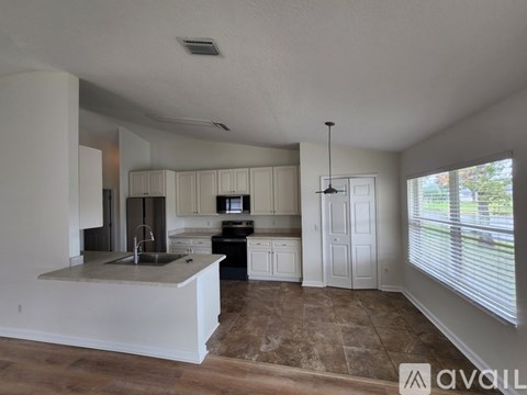 A kitchen with white cabinets and a marble countertop.