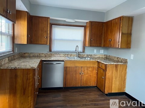 A kitchen with wooden cabinets and a granite countertop.