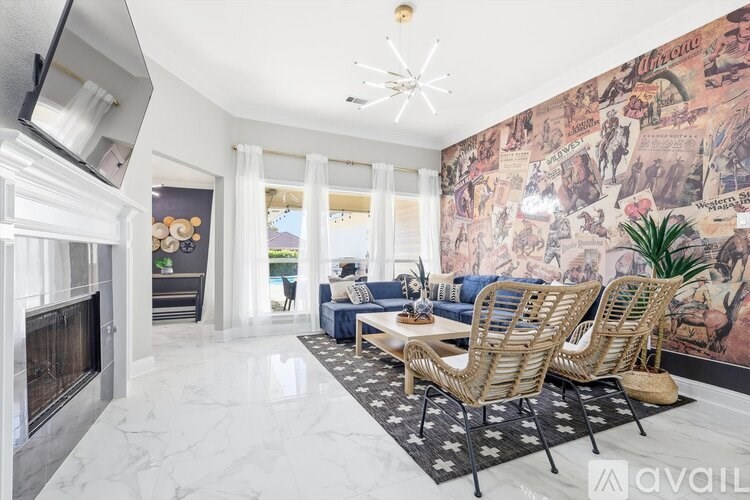 A living room with a fireplace and a large mural on the wall.
