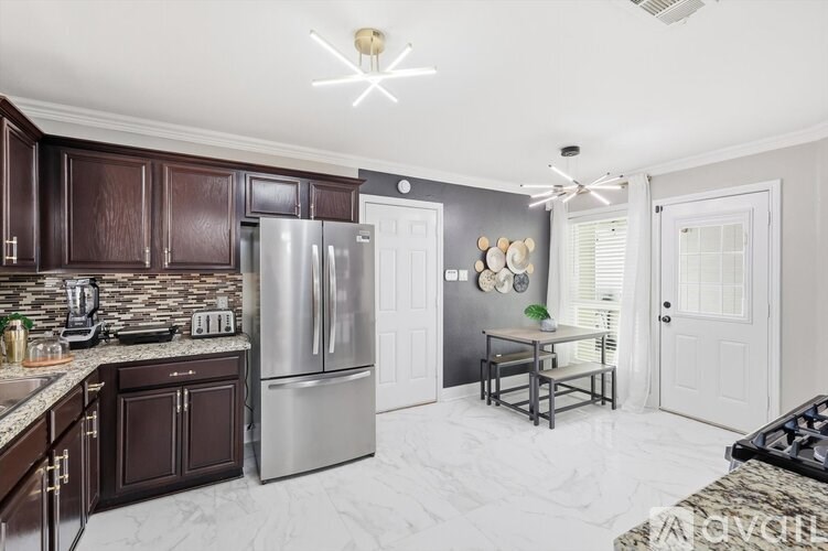 A kitchen with dark wood cabinets and a marble floor.