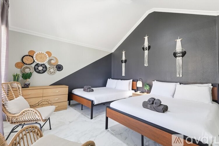 A bedroom with two beds and a chair.