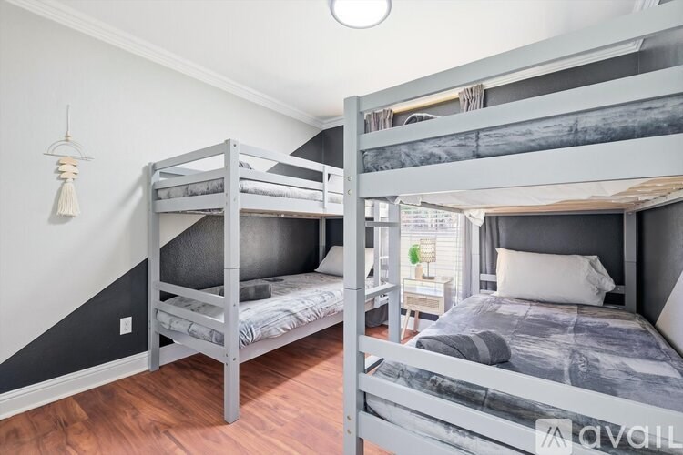A bedroom with two bunk beds and a nightstand.