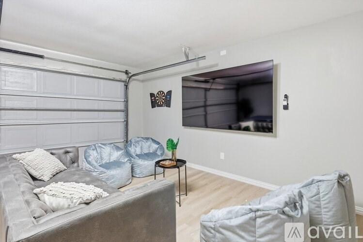 A living room with a grey couch and a grey bean bag chair.