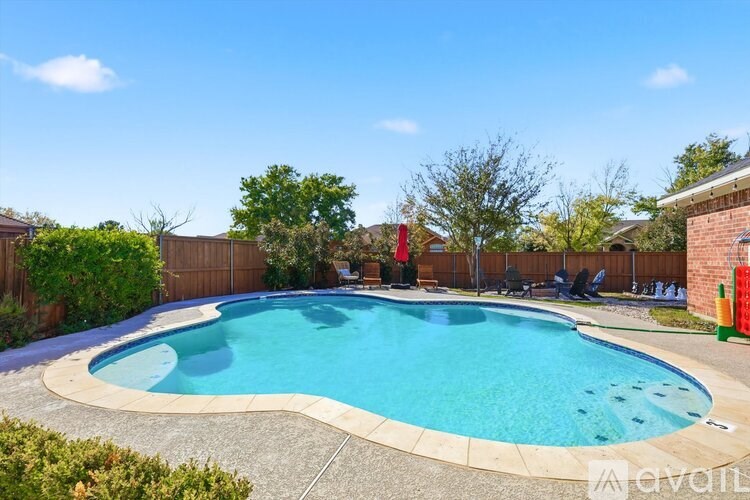 A swimming pool surrounded by a fence and trees.