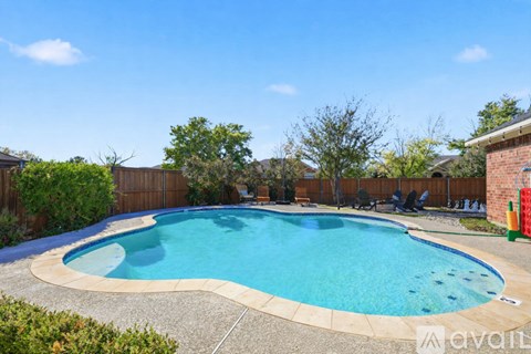 A swimming pool surrounded by a fence and trees.