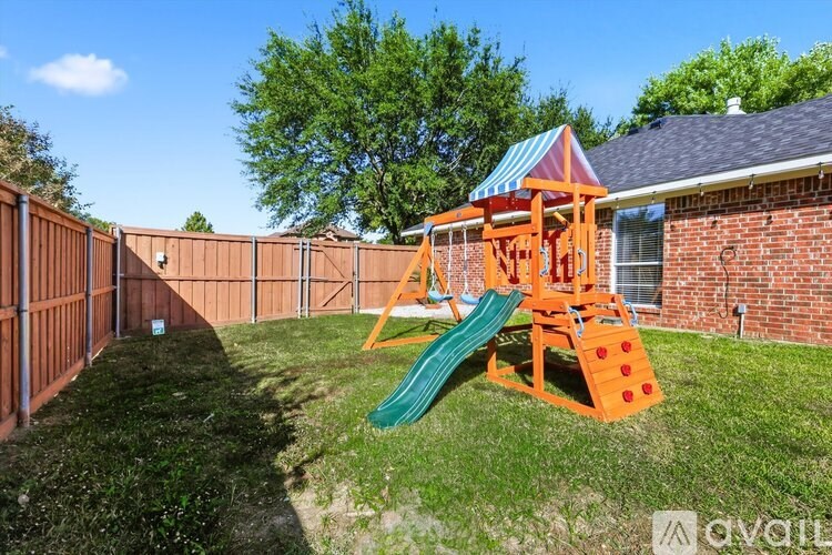 A playground with a green slide and a red and white roofed structure.