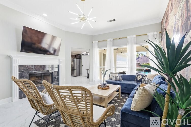 A living room with a fireplace and a dining table with chairs.