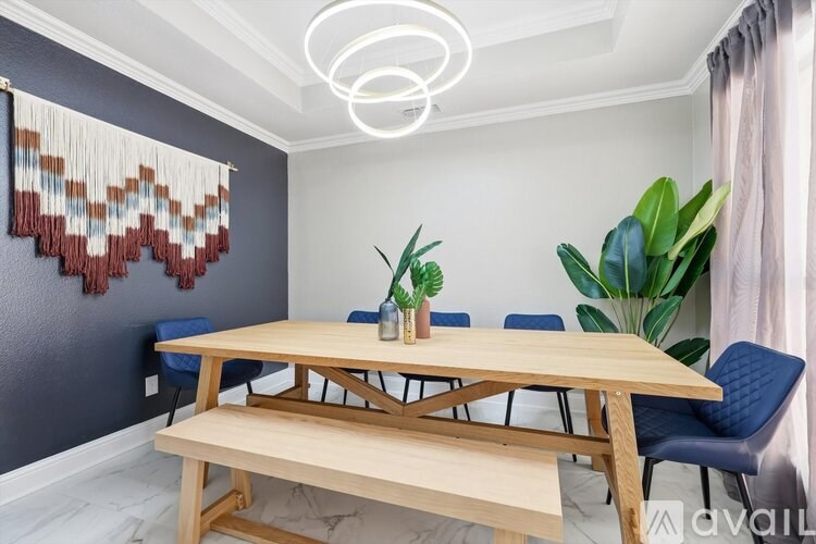 A dining room with a wooden table and blue chairs.