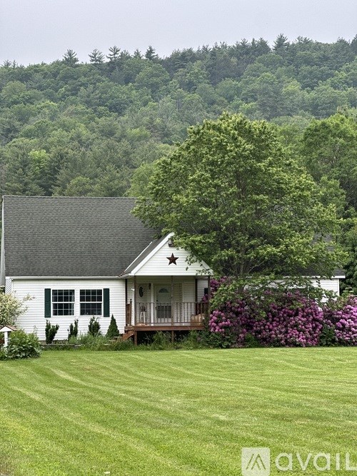 A white house with a black roof and a star on the front.