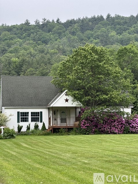 A white house with a black roof and a star on the front.