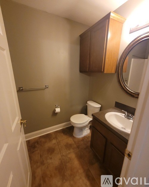 A bathroom with brown cabinets and a white toilet.