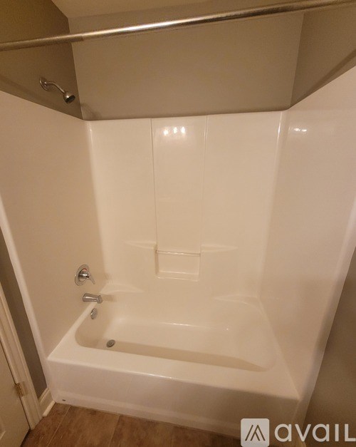 A white bathtub with a silver faucet is in a bathroom.