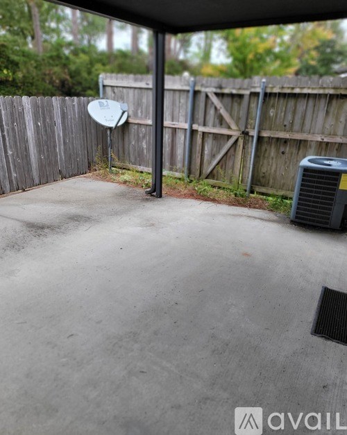A patio with a satellite dish and a fence.