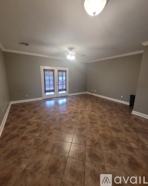 A room with brown tiled flooring and a white door.