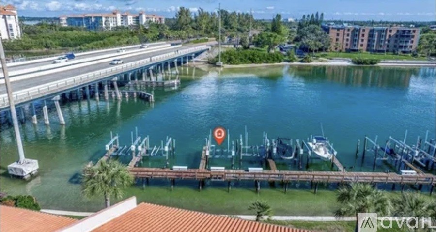 A bridge over a body of water with boats docked at a pier.