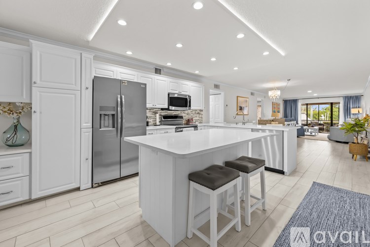 A modern kitchen with white cabinets and a central island.