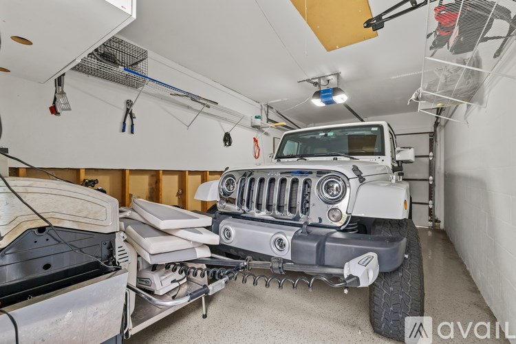 A Jeep is parked in a garage with a boat lift system.