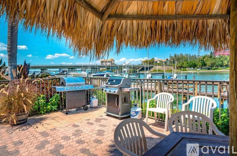 A patio with a table and chairs overlooking a body of water.