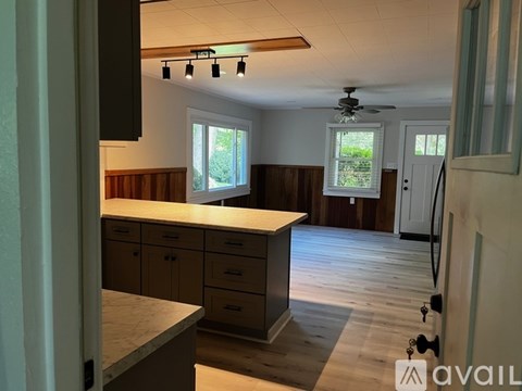 A kitchen with wooden cabinets and a countertop is available for rent.