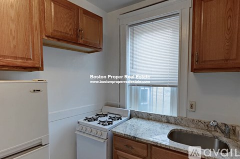 A kitchen with wooden cabinets and a white stove top oven.