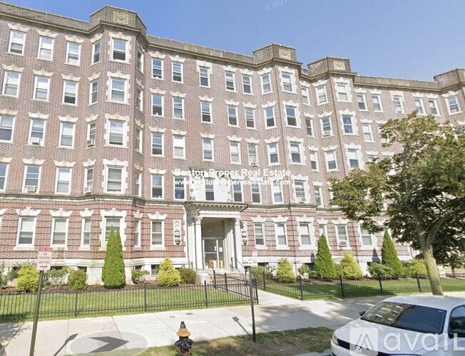 A large red brick building with a sign that says "Sunrise Prop Real Estate".