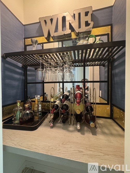 A wine rack with bottles and glasses on it.