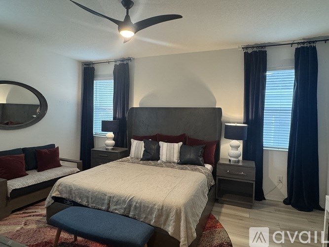 A bedroom with a large bed and a ceiling fan.
