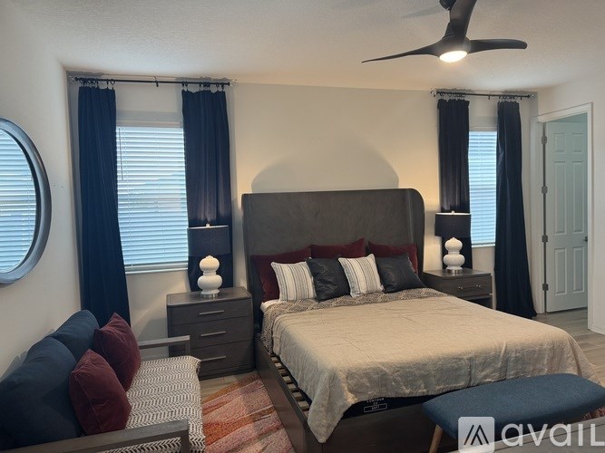 A bedroom with a large bed and a ceiling fan.