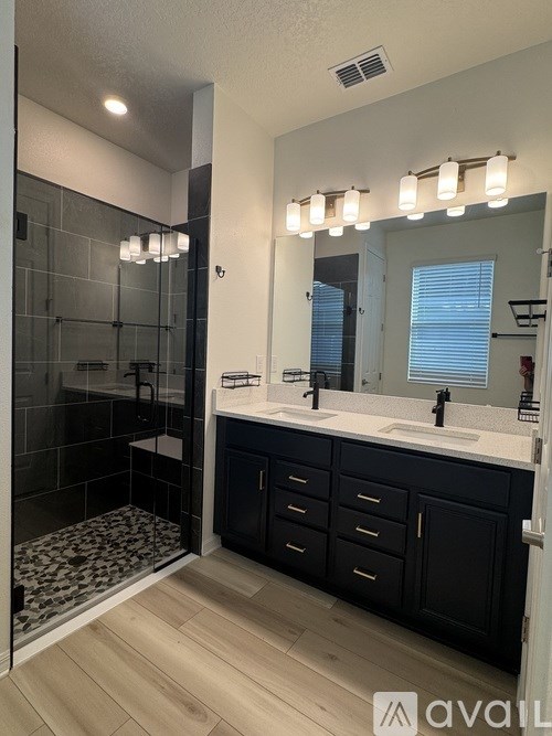 A bathroom with a black cabinet and a white countertop.