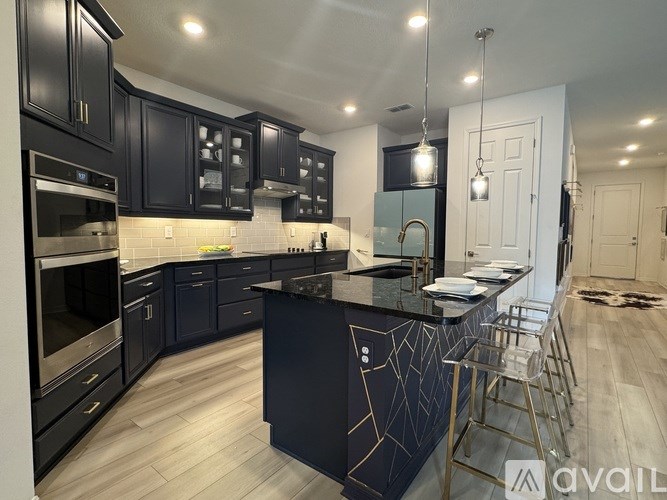A modern kitchen with dark cabinets and a black island.