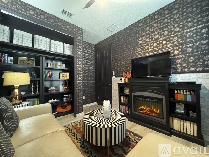 A living room with a fireplace and a television on the wall.