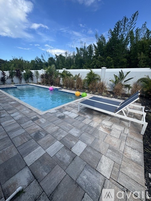 A pool with a tiled floor and a sun lounger.