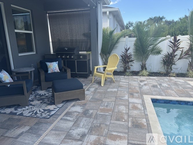 A patio with a pool and a yellow chair.