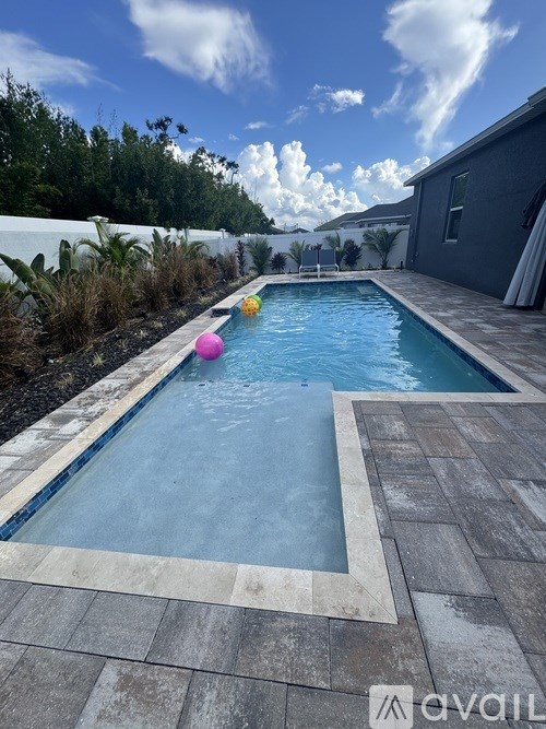 A pool with a blue tiled edge and a brown tiled floor.