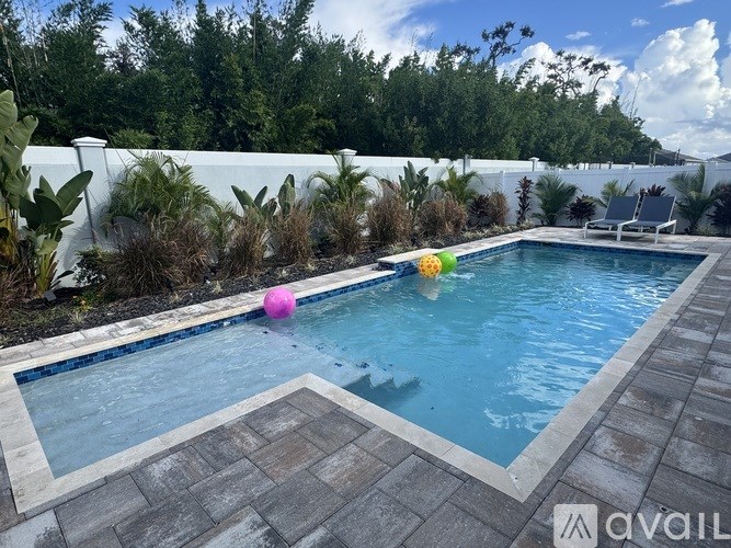 A pool with a pink ball and a yellow ball floating in it.