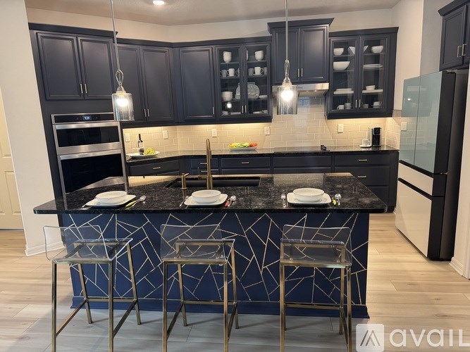 A kitchen with black cabinets and a black island with a geometric pattern.