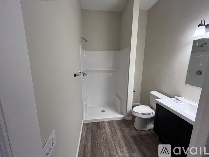 A bathroom with a toilet, sink, and shower.