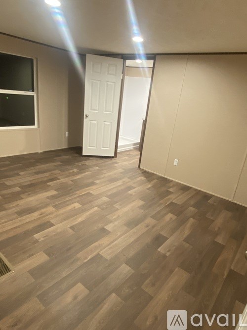 A room with wooden flooring and a white door.