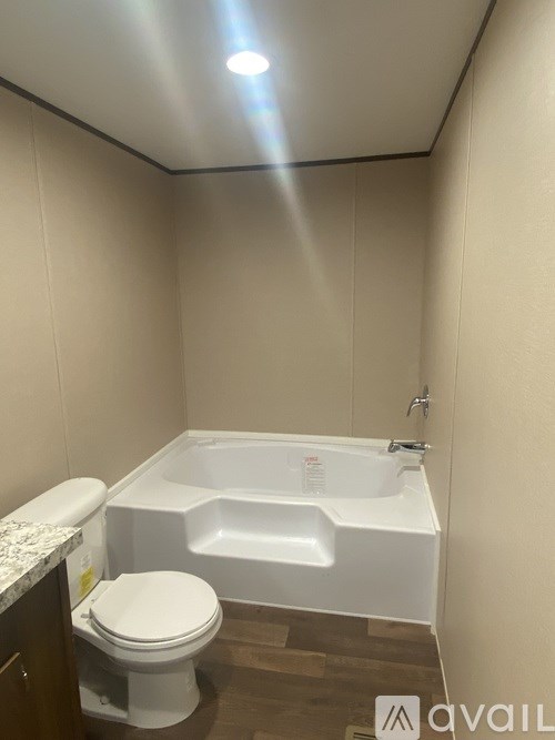A white toilet sits next to a white bathtub in a small bathroom.