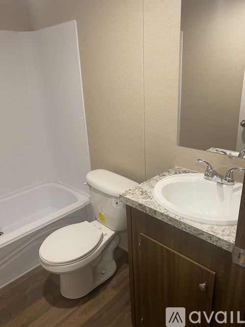 A white toilet with a white tub in a bathroom.