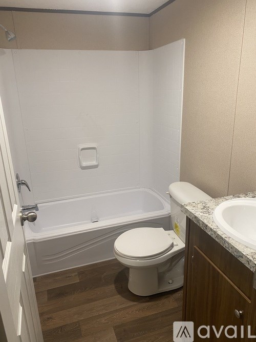 A white toilet sits next to a bathtub in a bathroom.