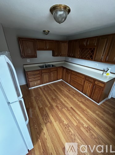A kitchen with wooden floors and white appliances.