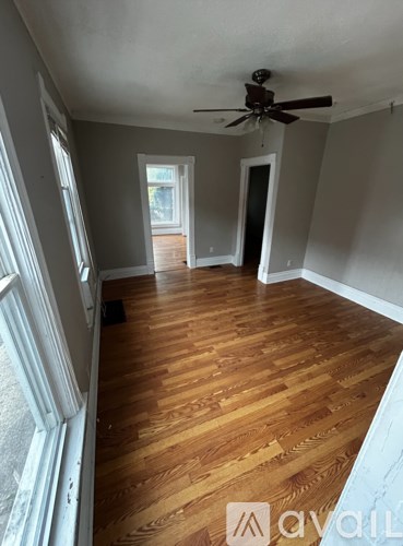 A room with wooden floors and a ceiling fan.