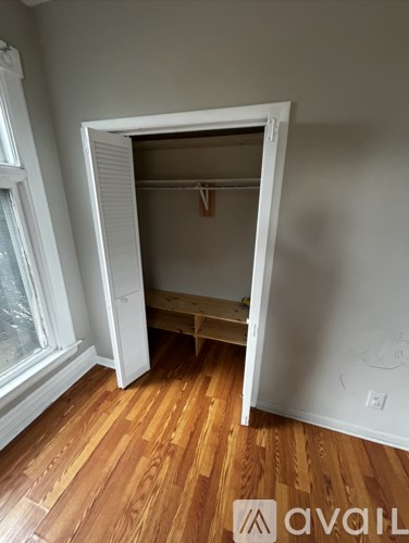 A room with a white door and wooden floors.