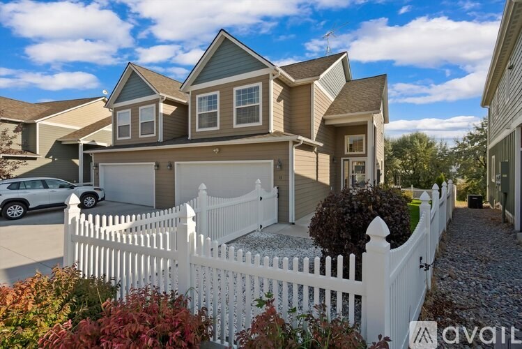 A house with a white picket fence in front of it.